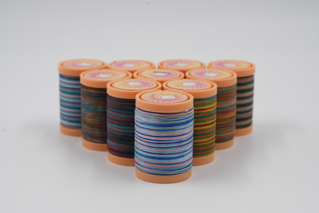 Rainbow colored flat wax thread for leather crafting” “Flat waxed polyester thread close-up” “Leather stitching with multicolor flat wax thread” “Durable waxed thread in rainbow colors for DIY crafts”