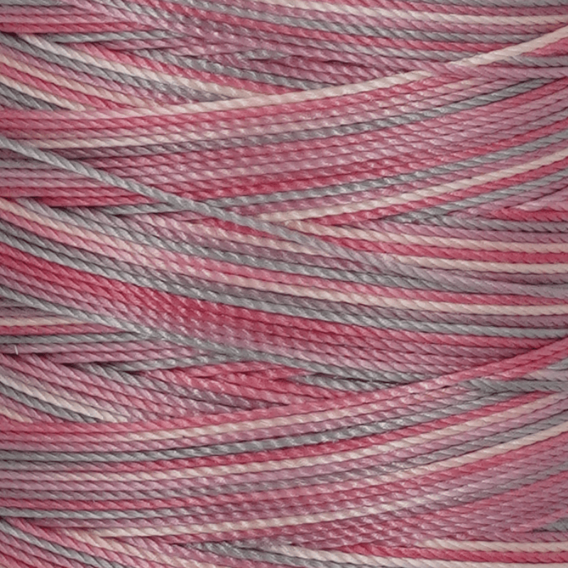 Close up of pink gray and beige variegated yarn strands wound together