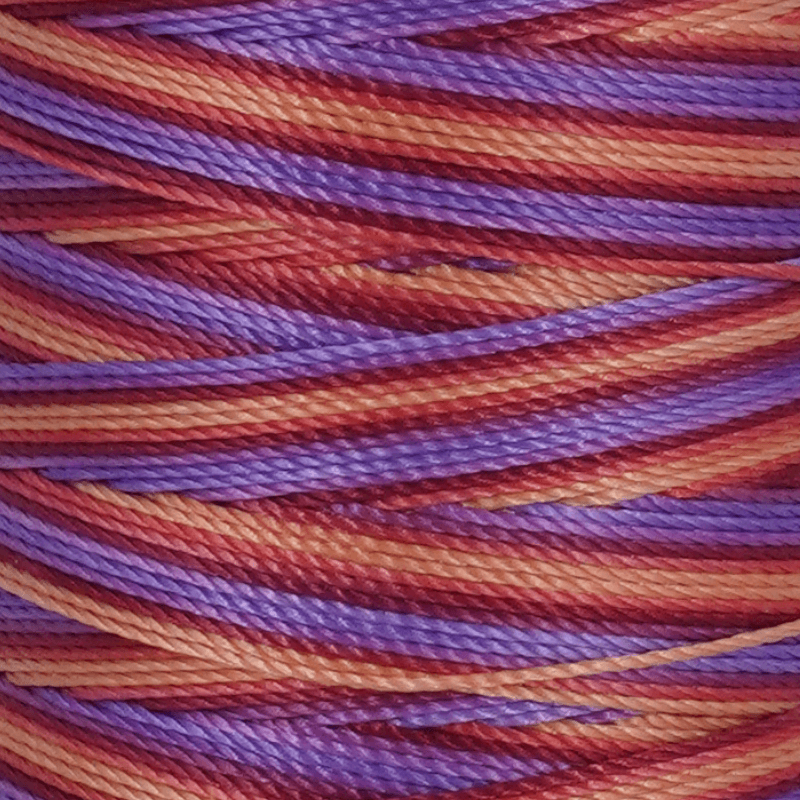 Close up of intertwined purple and orange yarn strands showing twisted fibers
