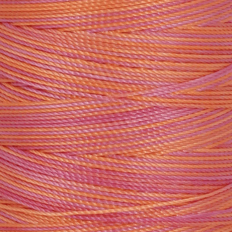 Close up of pink and orange twisted yarn strands intertwined together for knitting or craftwork